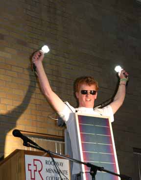 Photovoltaic Man wears a solar panel and holds up lit lightbulbs